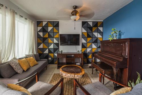 a living room with a couch and a piano at Casa Tulita Mérida in Mérida