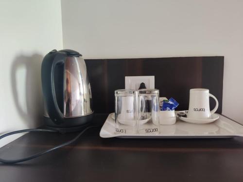 a tray with cups and a coffee maker on a table at Boros Resorts Binsar in Almora