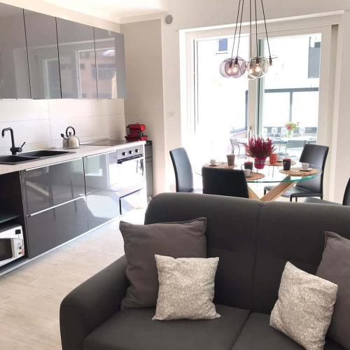 a living room with a couch and a kitchen at Magnolia Guest House Salerno in Salerno