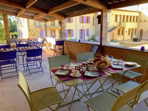 einen Tisch mit Speisen und Stühlen auf einer Terrasse in der Unterkunft Château Ferrassières in Ferrassières