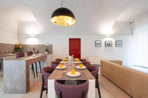 a dining room with a long table and purple chairs at Borgo di Drugolo in Lonato del Garda