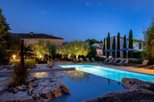 een zwembad in een tuin met een resort bij Le Mas du Terme in Barjac