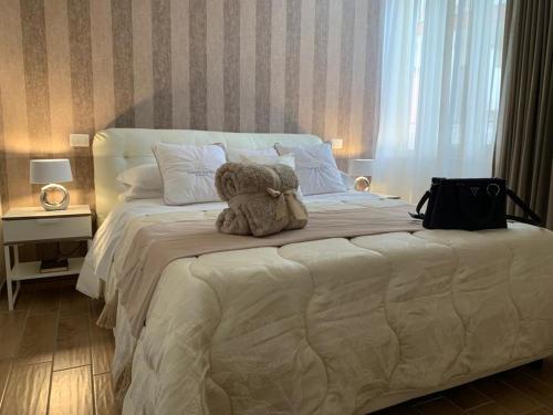a teddy bear sitting on top of a bed at Pompei Luxury Suite in Pompei