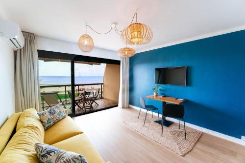 a living room with a couch and a table at Hôtel Café Miramar in Le Grau-du-Roi