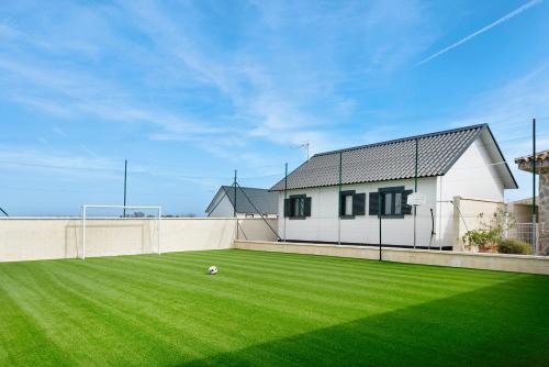 a yard with a soccer ball in the grass at Casa Manoli in Hozanejos