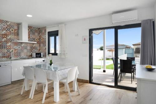 a kitchen and dining room with a white table and chairs at Casa Manoli in Hozanejos