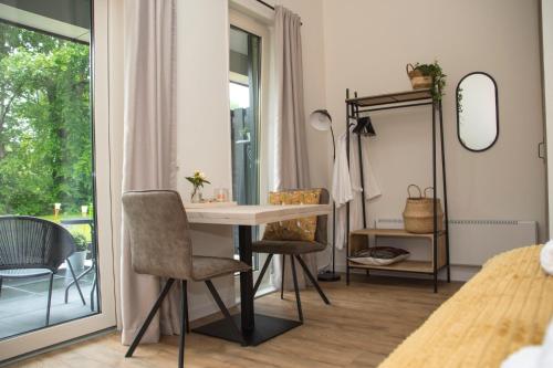 Zimmer mit einem Tisch, Stühlen und einem Spiegel in der Unterkunft De Burcht-Drenthe in Bunne