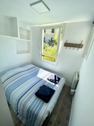 une petite chambre avec un lit et une fenêtre dans l'établissement Maison les pieds dans l'eau, à Villefort