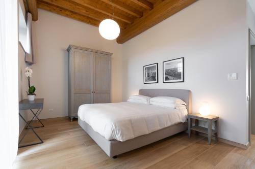 a bedroom with a white bed and a wooden ceiling at Borgo di Drugolo in Lonato del Garda