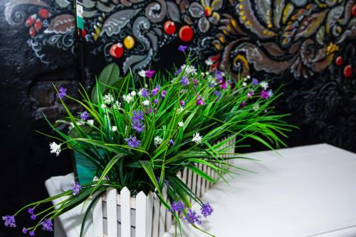 a white vase filled with purple and white flowers at Metelitsa Hotel in Karagandy