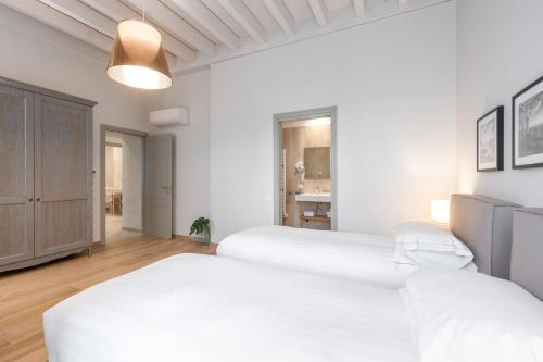 two beds in a bedroom with white walls at Borgo di Drugolo in Lonato del Garda