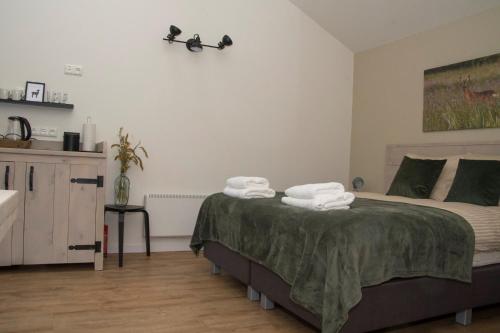 a bedroom with a bed with towels on it at De Burcht-Drenthe in Bunne