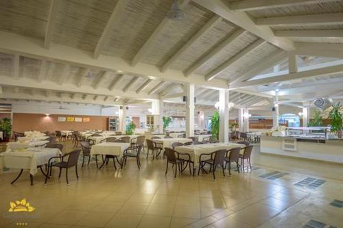ein Esszimmer mit Tischen und Stühlen in einem Restaurant in der Unterkunft Hotel Garden Beach in Castiadas