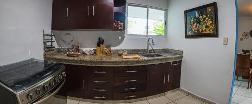a kitchen with a sink and a stove at Casa Tulita Mérida in Mérida