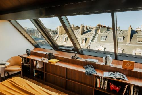 a bedroom with a large window with a view of a city at Hôtel Madame Rêve in Paris
