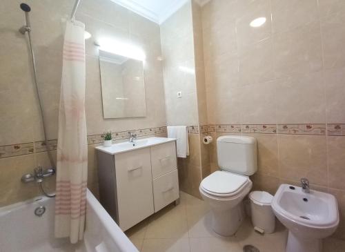 een badkamer met een toilet, een wastafel en een bad bij COLINA FÉRIAS- Garagem & WIFI in Quarteira