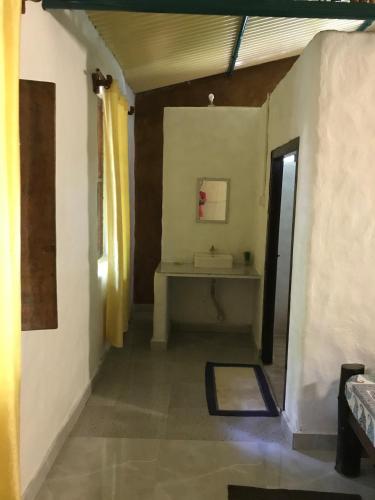 a hallway of a room with a sink and a table at Kamp Kamouflage Kanha in Kānha