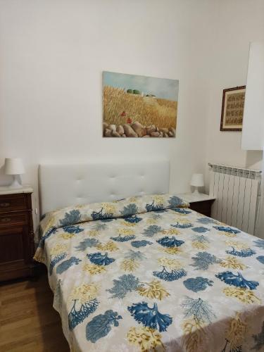 ポリニャーノ・ア・マーレにあるVilla Massa Piscinaのベッドルーム1室(青と白の掛け布団付きのベッド1台付)