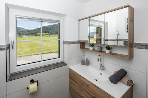 a bathroom with a sink and a window at Appartements HOAMATGFÜHL in Sankt Margarethen im Lungau