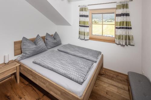 a bed in a room with a window at Appartements HOAMATGFÜHL in Sankt Margarethen im Lungau