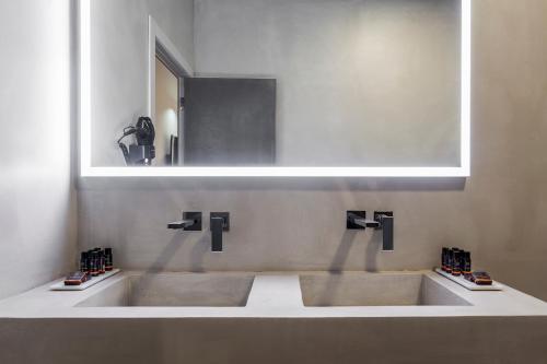 une salle de bain avec deux lavabos et un miroir dans l'établissement NALU Valencia Boutique Rooms, à Valence