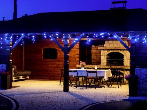 a patio with a table and blue lights at Hotel Feniks in Gniezno