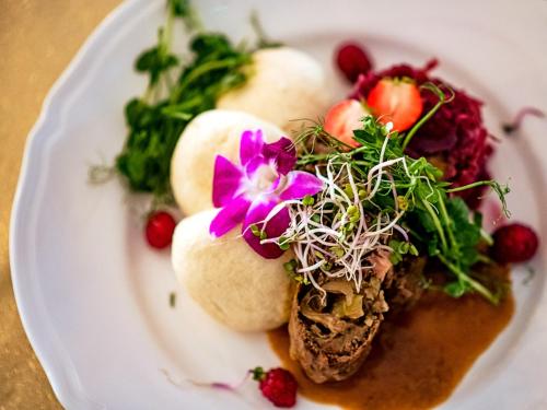 a plate of food with a flower on it at Hotel Feniks in Gniezno