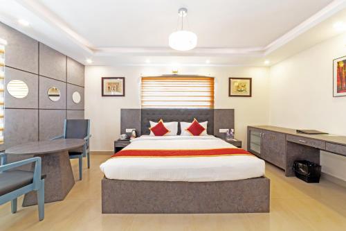 a bedroom with a large bed and a desk and a desk at Icon Regency by Bhagini in Bengaluru