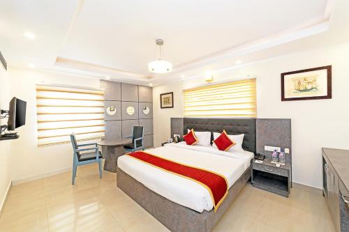 a hotel room with a large bed and a desk at Icon Regency by Bhagini in Bangalore
