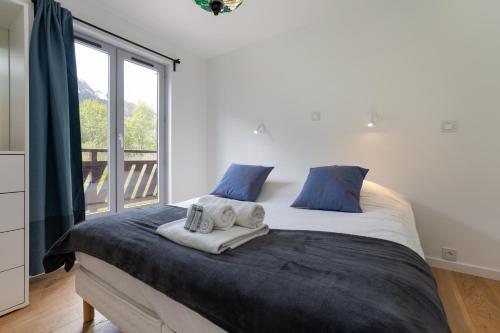 een slaapkamer met een groot bed en handdoeken bij Appartement Lyret II B22 - Happy Rentals in Chamonix-Mont-Blanc