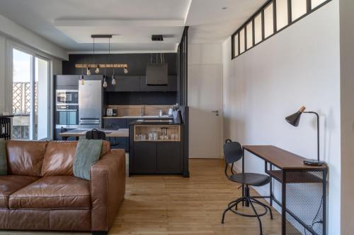 un salon et une cuisine avec un canapé et une table dans l'établissement Le Manège - Spacieux T2 avec Terrasse au coeur de Nantes, à Nantes