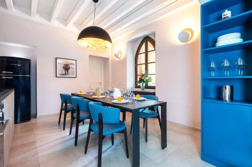 a dining room with a black table and blue chairs at Borgo di Drugolo in Lonato del Garda