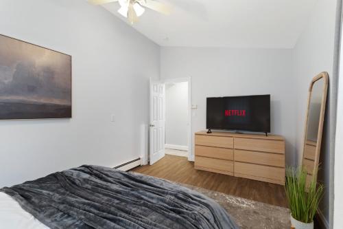 a bedroom with a bed and a tv on a dresser at New Stylish Beach Home near Stamford Downtown/Cove Beach/ 40 min to NYC in Stamford
