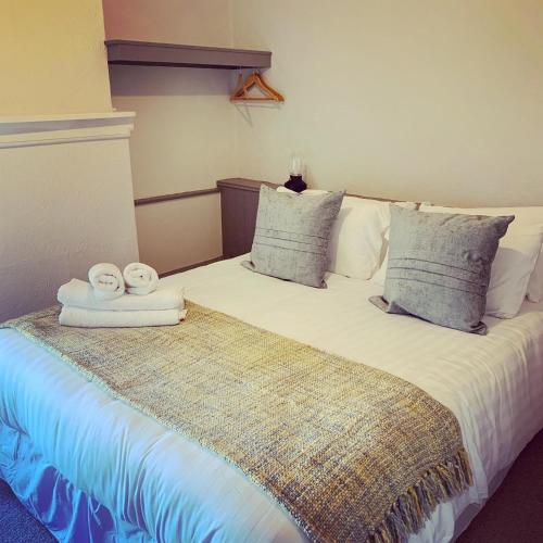 a bedroom with a bed with two towels on it at Black Bull Inn in Haworth