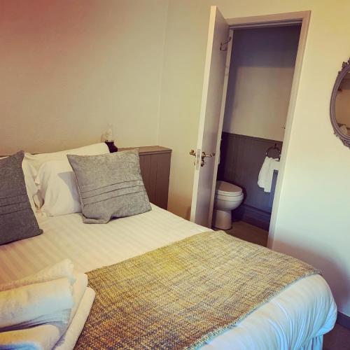 a small bedroom with a bed and a toilet at Black Bull Inn in Haworth