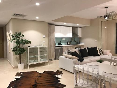 Jutta Deluxe 2,5-Bedroom-Apartment Mangroovy-M10 El Gouna في الغردقة: غرفة معيشة مع أريكة ومطبخ