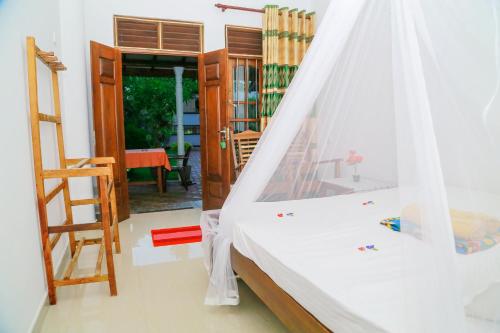 a bedroom with a bed with a net at Sanda Hiru Guest in Mirissa