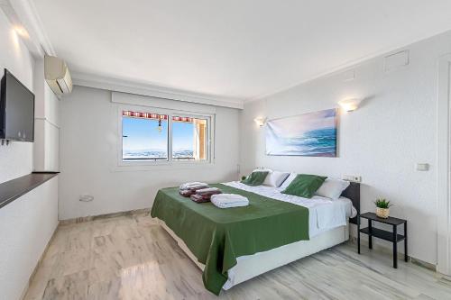 ein Schlafzimmer mit einem großen Bett und einer grünen Decke in der Unterkunft Stunning sea and mountains views close to the beach ! in Benalmádena