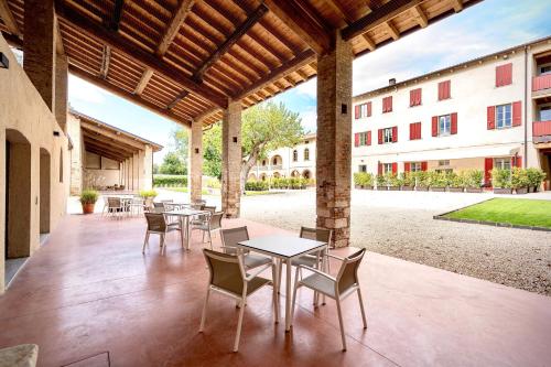 a patio with tables and chairs and a building at Borgo di Drugolo in Lonato del Garda