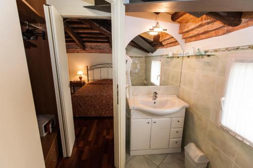 uma casa de banho com um lavatório e uma cama num quarto em Residence Bertolini em Pádua