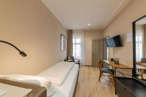 a hotel room with a bed and a desk at Hof Ehrenfels in Mainz