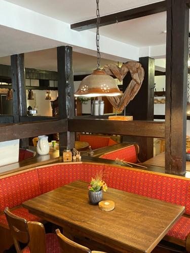 a dining room with a wooden table and red chairs at Deutsche Eiche Hotel & Restaurant in Dassel