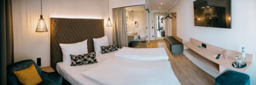 Habitación de hotel con cama y baño en LOOM Hotel & Skybar, en Eislingen