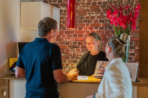 a woman sitting at a counter talking to a man at Hof Ehrenfels in Mainz