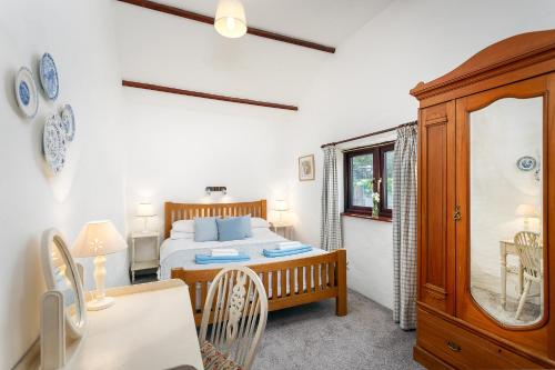 En eller flere senge i et værelse på The Snug at Cornish Barn Holidays