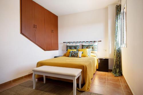1 dormitorio con 1 cama con colcha amarilla en Casa Ariadna en Costa de Antigua