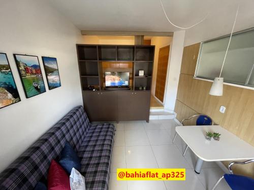 ein Wohnzimmer mit einem Sofa und einem Tisch in der Unterkunft Flat à Beira Mar na Barra in Salvador