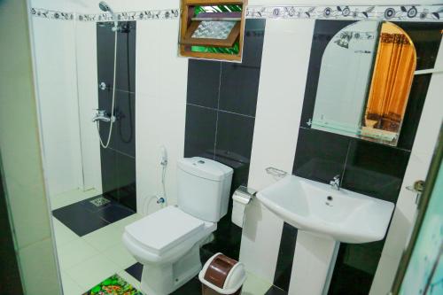 a small bathroom with a toilet and a sink at Sanda Hiru Guest in Mirissa