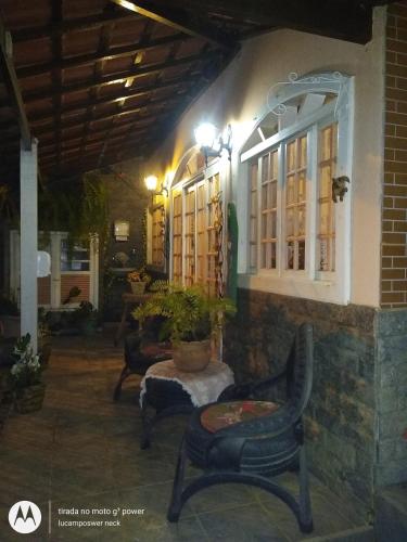 a patio with chairs and a table and windows at Pousada Oca Porã in Conservatória