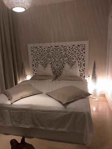 a bedroom with a large white bed with lights at Jutta Deluxe 2-Bedroom-Apartment Mangroovy-M7 El Gouna in Hurghada